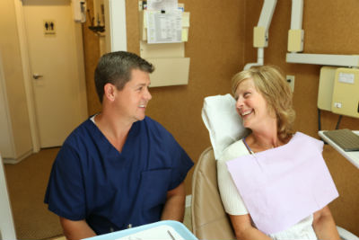 A patient laughing with Dr. Bomstad during a visit at Bomstad Dental in Hopkins